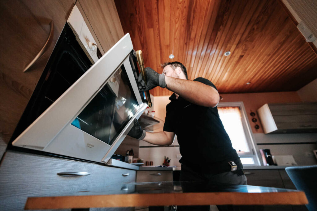 Photo de Julien BOUVIER entrain d'installer un Gros électroménager dans une cuisine à Rumilly